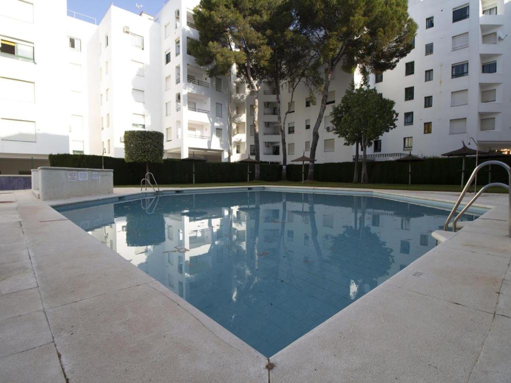 a swimming pool in front of a building at Lightbooking Ancora Cádiz in El Puerto de Santa María