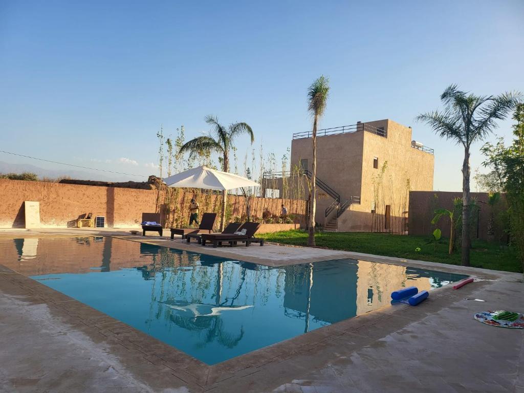 a swimming pool in a yard with palm trees at Dar Sofia Villa in Marrakesh