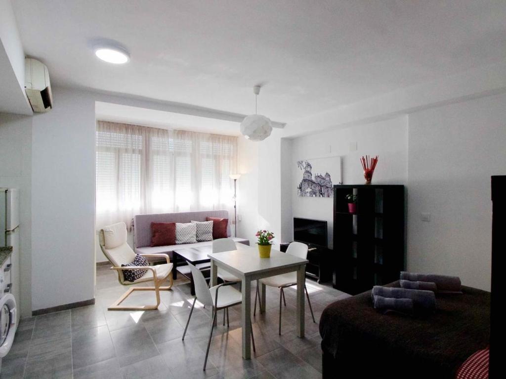 ein Wohnzimmer mit einem Tisch und einem Sofa in der Unterkunft Lightbooking Estadio Cádiz in Cádiz