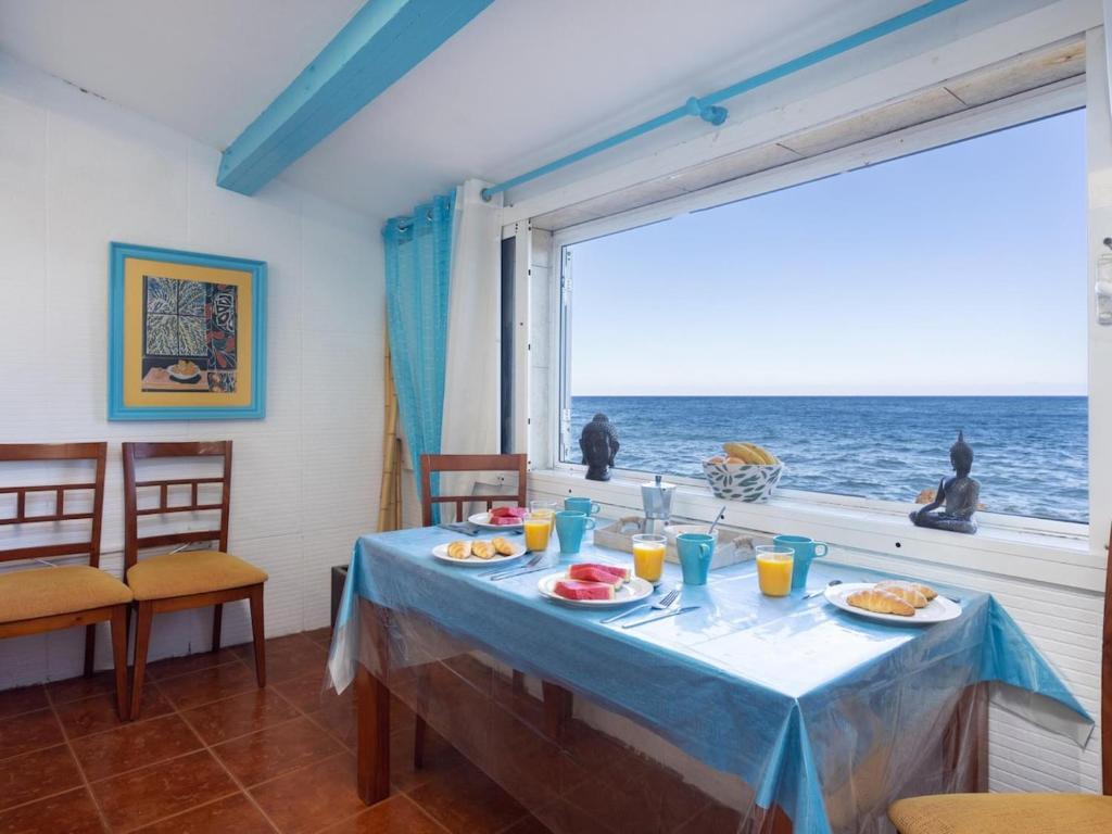 a dining room with a table with a view of the ocean at Lightbooking casa de playa Tenerife in Santa Cruz de Tenerife