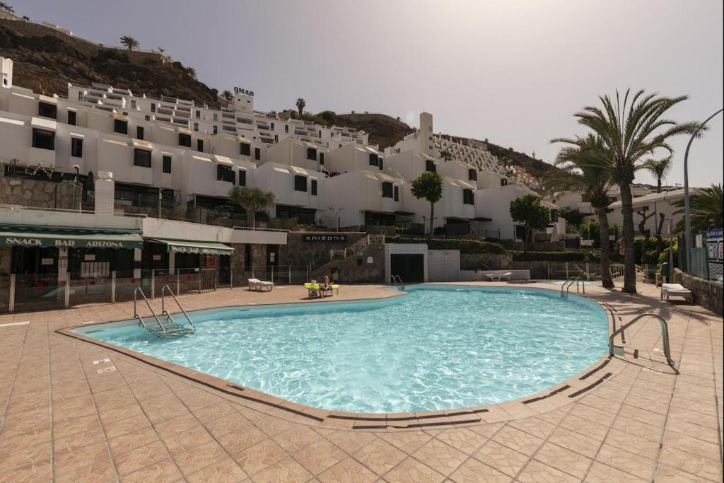 a large swimming pool in front of a large building at Lightbooking Arizona Puerto Rico in Puerto Rico de Gran Canaria