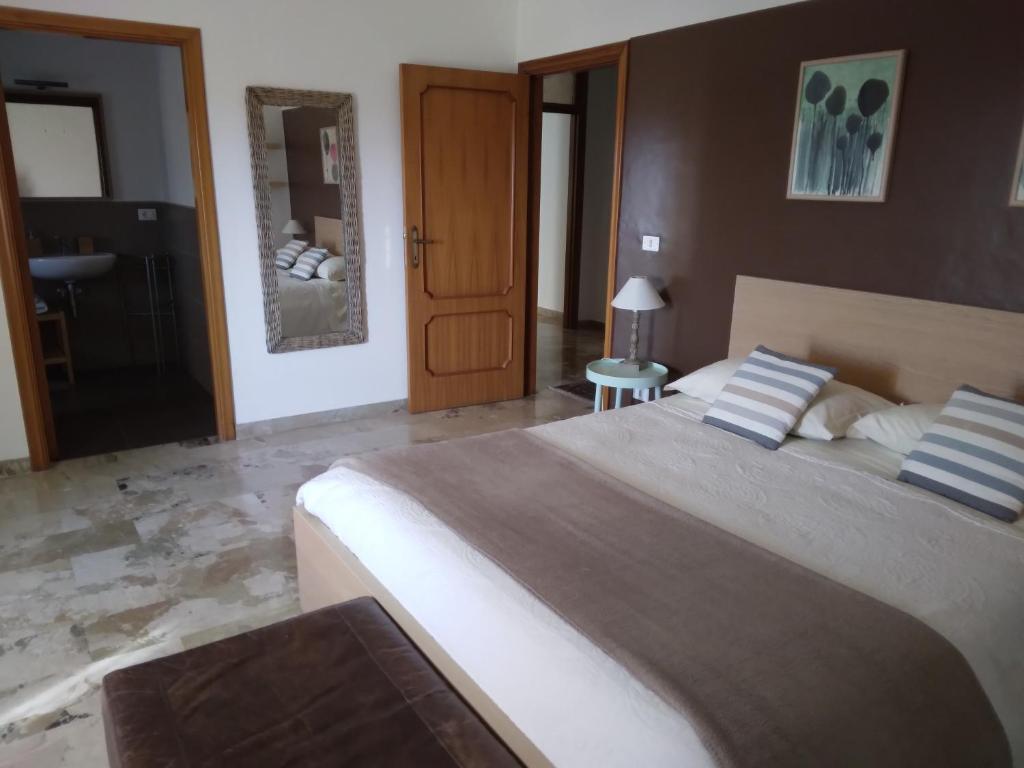 a bedroom with a large bed and a bathroom at B&Be Home in Tollo