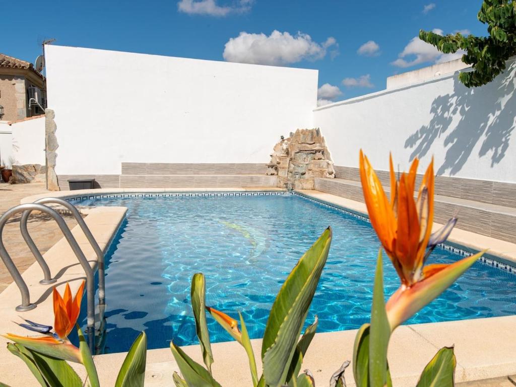 una piscina con flores naranjas frente a un edificio en Lightbooking Blanca Paloma Cádiz, en El Puerto de Santa María