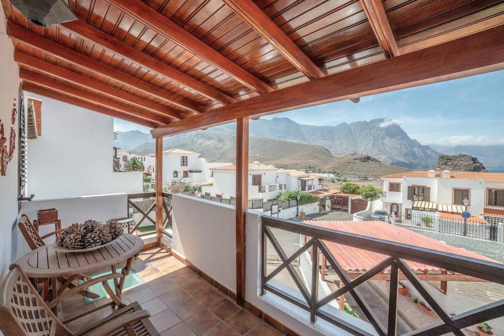 balcón con mesa y vistas a las montañas en Lightbooking Janeth Agaete, en Agaete