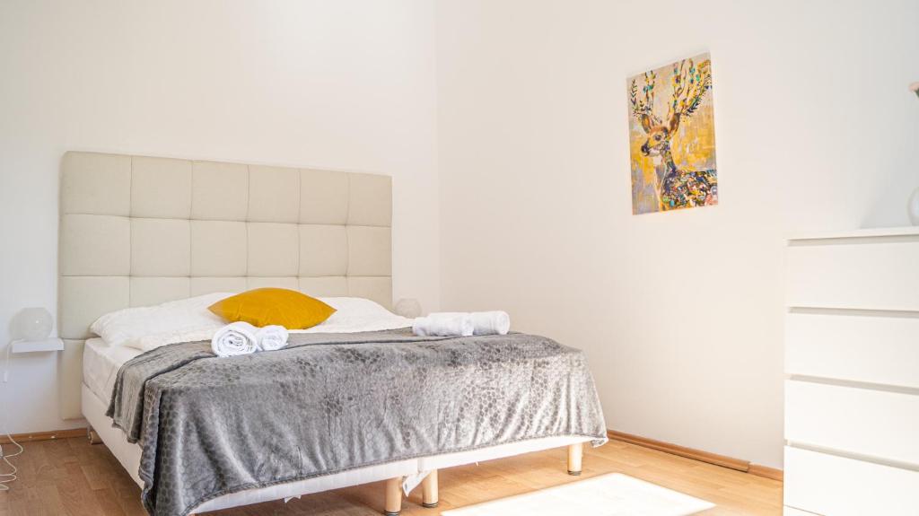 Un dormitorio blanco con una cama con toallas. en Sleek & Subtle/Minimalist 4BR Apt.@ Prime Location en Viena