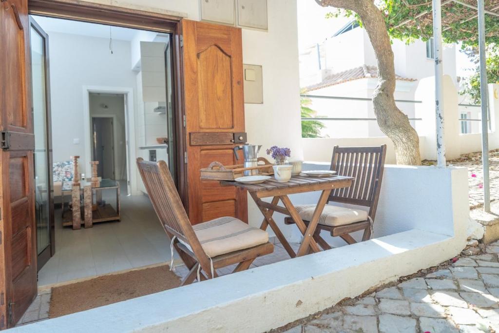 eine Terrasse mit einem Holztisch und 2 Stühlen in der Unterkunft Lightbooking Praia Fabrica Algarve in Vila Nova De Cacela