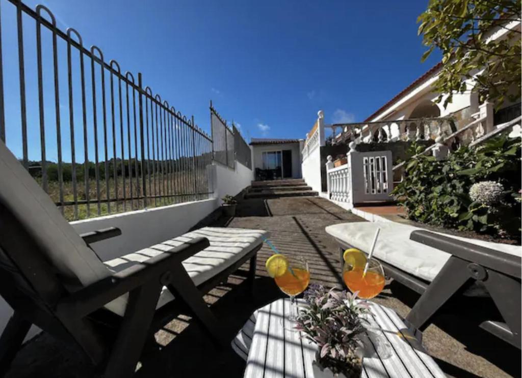 a patio with a bench and a table and a fence at Lightbooking Agua Garcia Tacoronte con terraza in Tacoronte