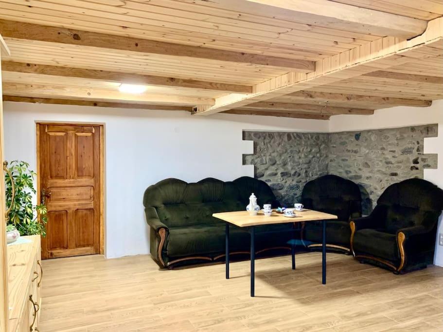 ein Wohnzimmer mit 2 grünen Sofas und einem Tisch in der Unterkunft La-Marti, Idyllische Unterkunft mit Kamin in Bagdatʼi