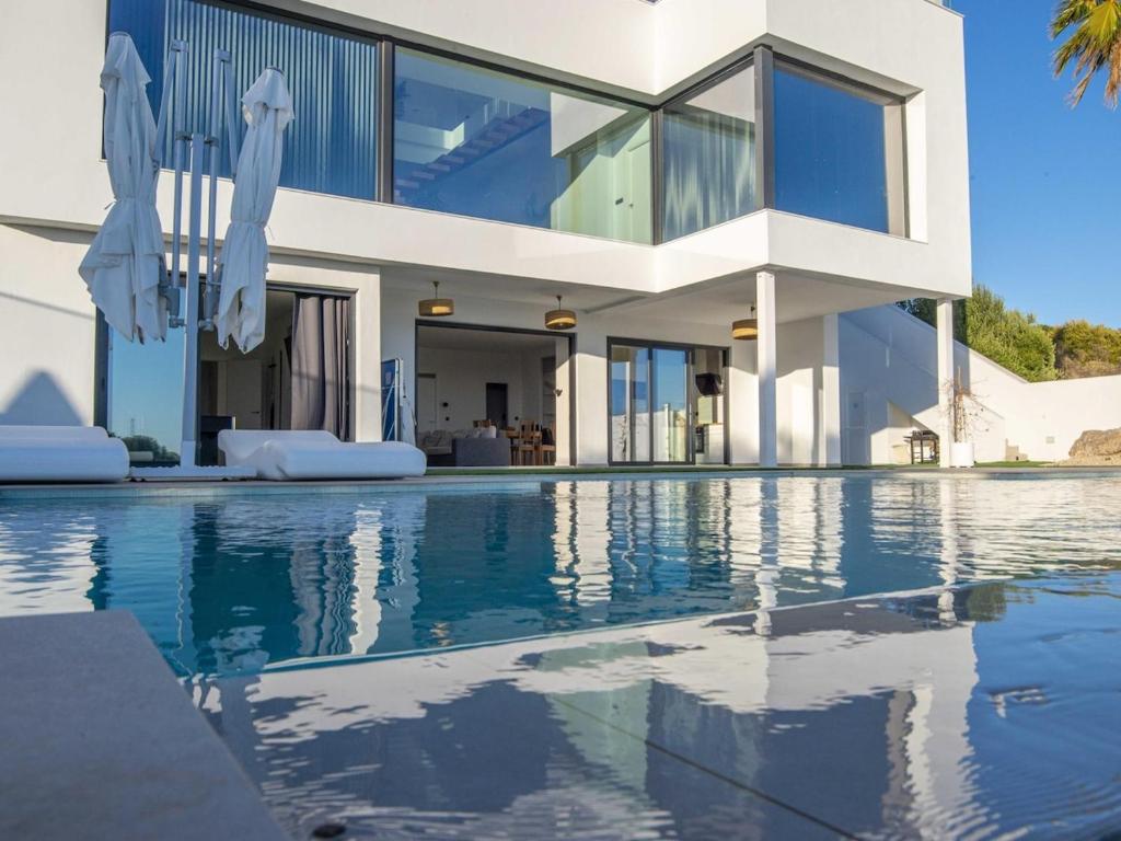 una casa con piscina frente a una casa en Lightbooking Montecastillo Moto GP en Jerez de la Frontera
