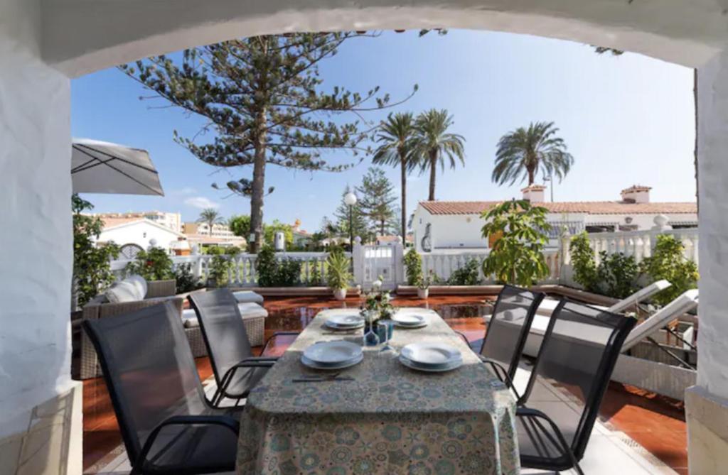 un patio con mesa de comedor y sillas y vistas en Lightbooking Santa Barbara Playa del Ingles, en Maspalomas