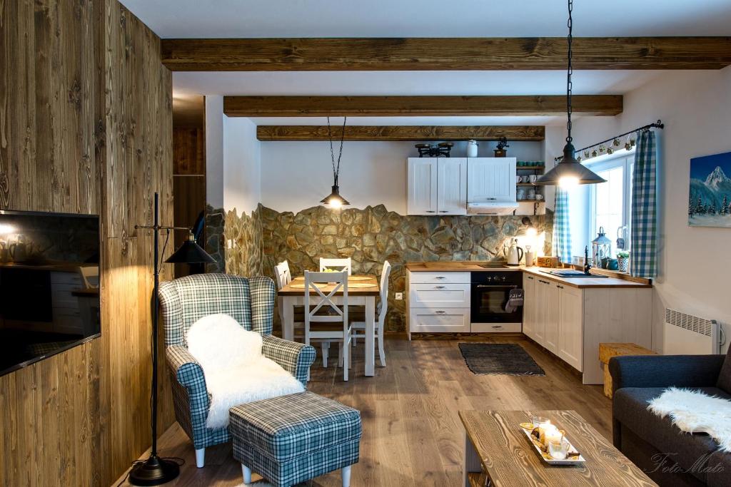 uma cozinha e sala de estar com mesa e cadeiras em Horský apartmán Vrátna-Saška em Terchová