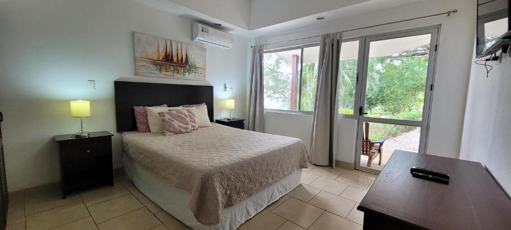 a bedroom with a bed and a large window at Villas Eco Development in Playa Junquillal
