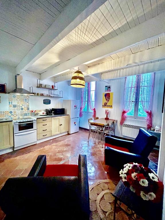 Il comprend une cuisine et un salon avec des chaises et une table. dans l'établissement UN MOMENT SUSPENDU, à Aix-en-Provence