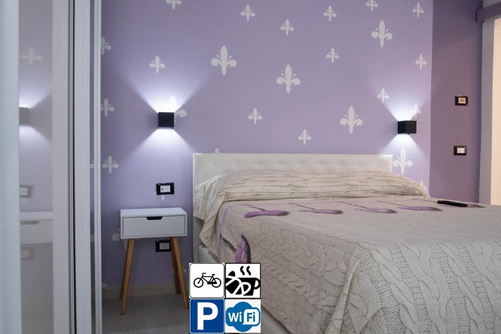 ein Schlafzimmer mit lila Wänden und ein Bett mit lila Bettwäsche in der Unterkunft Appartamento Vale Mare Vista Canale in Chioggia