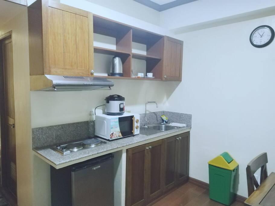 a kitchen with a sink and a microwave at Isabelle Garden Villas 509 in Manila