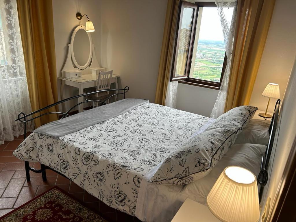 a bedroom with a bed and a mirror and a window at La Casa di Laura in Cortona