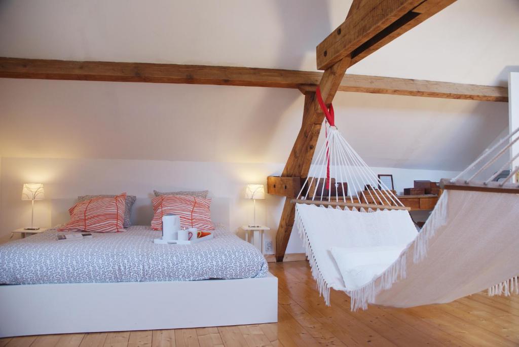 a bedroom with a bed and a hammock at La Vigie in Couëron