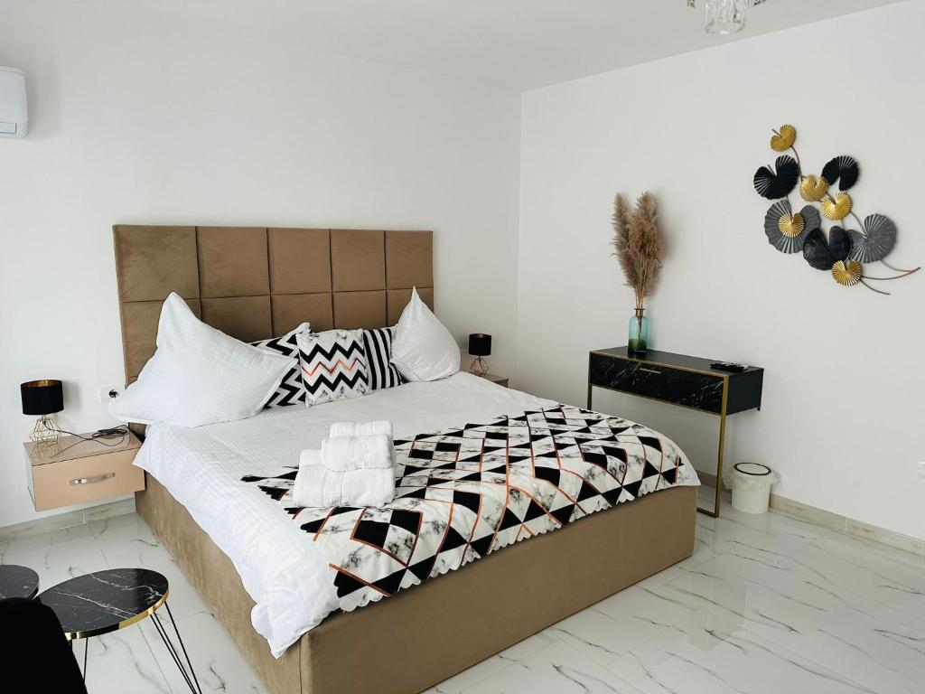 ein Schlafzimmer mit einem großen Bett mit weißen Wänden in der Unterkunft B&S Boutique Studio in Mamaia Nord – Năvodari