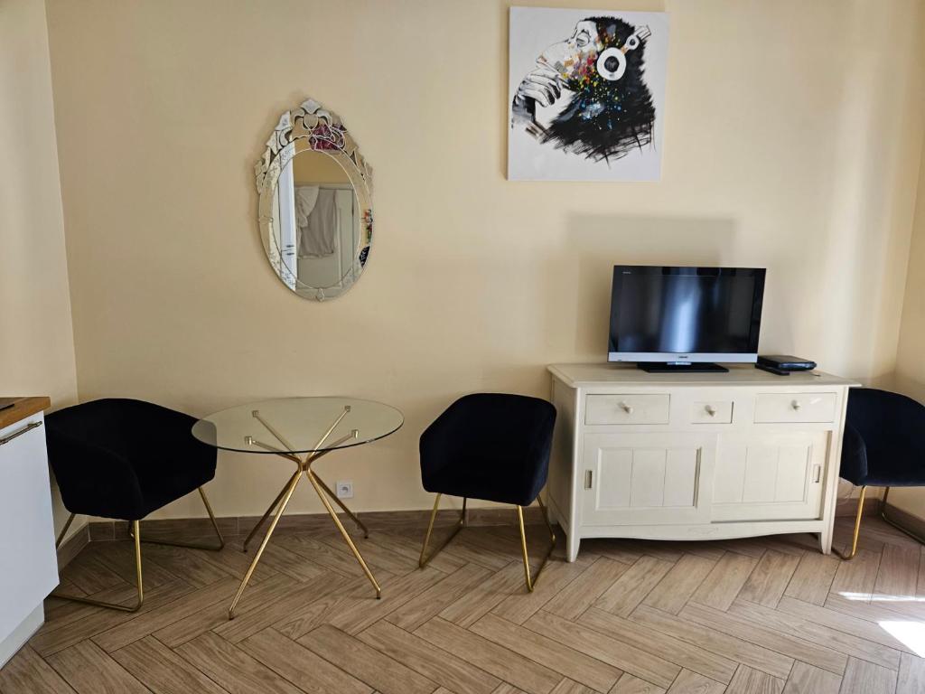 ボーソレイユにあるLe Sancy appartementのリビングルーム(椅子2脚、テーブル、鏡付)