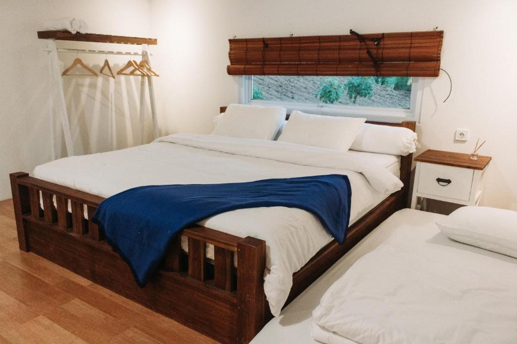 a bedroom with two beds and a window at Awana Farmhouse Dieng in Dieng