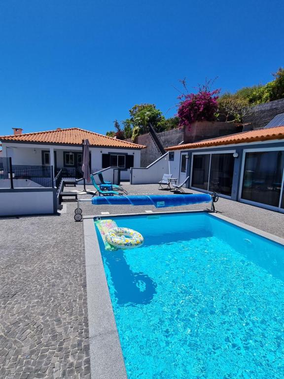 a swimming pool in the backyard of a house at Casa agapanthe in Estreito da Calheta