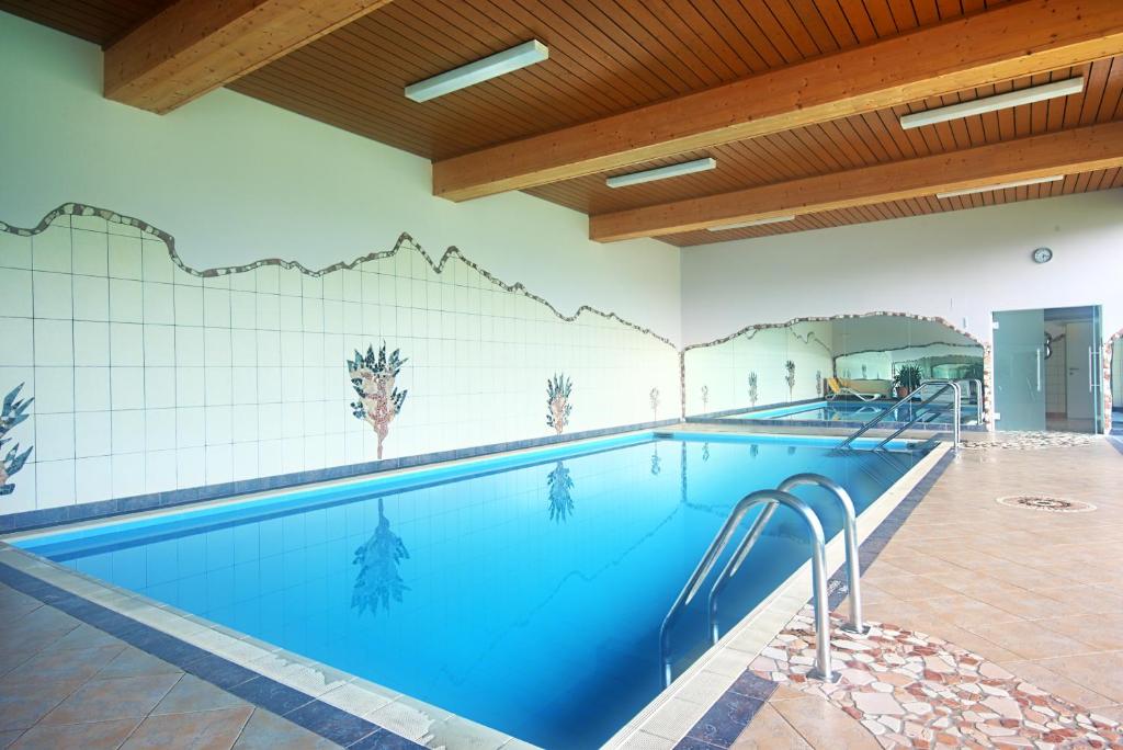 une grande piscine avec un mur en carrelage dans l'établissement Alpen Apartment Werfenweng - Ruhe - Pool, à Werfenweng