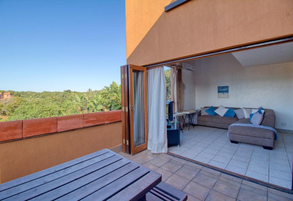 einen Balkon mit einem Sofa und einem Tisch in der Unterkunft San Lameer Villa 1916 by Top Destinations Rentals in Southbroom