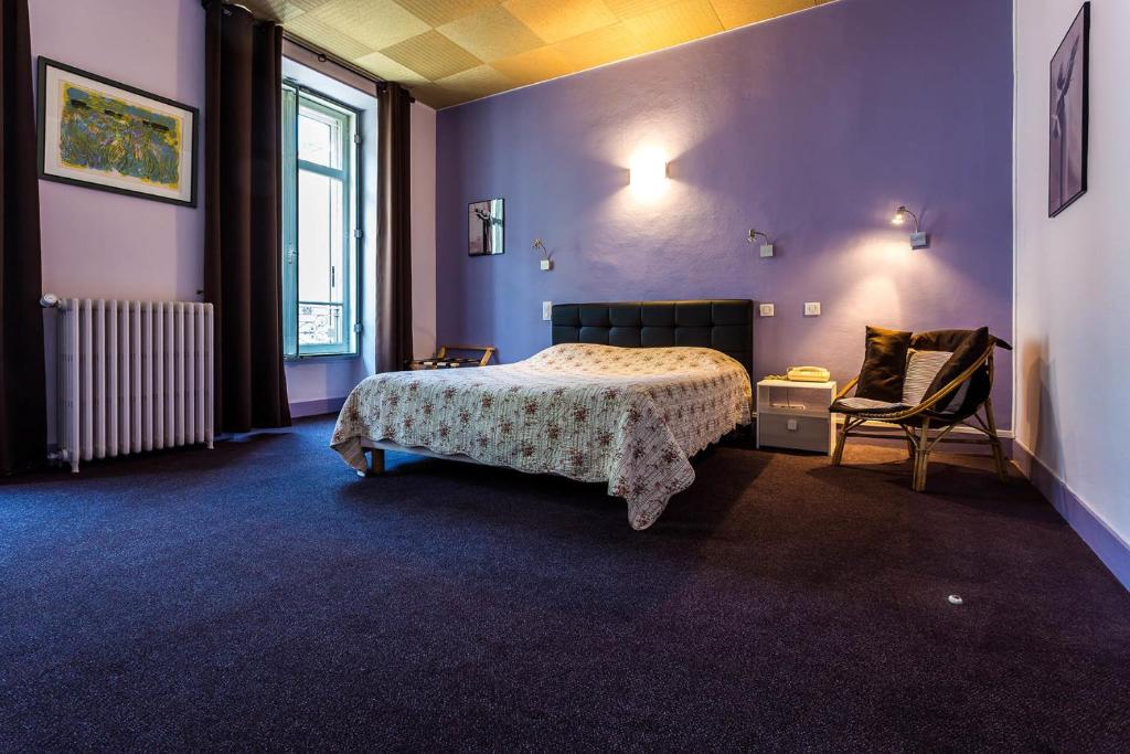 a bedroom with a bed and a chair in it at Hôtel Adour in Pau