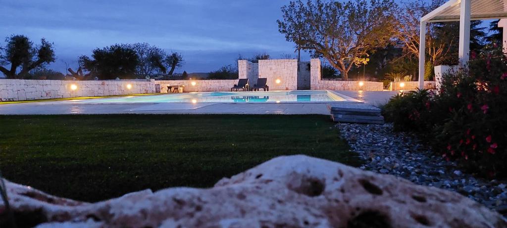 a backyard with a swimming pool at night at Dimora Carucci in Noci