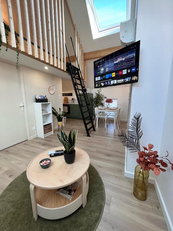 un salon avec une table et une télévision dans l'établissement Gîtes de la Chapelle, à Gigny-sur-Saône