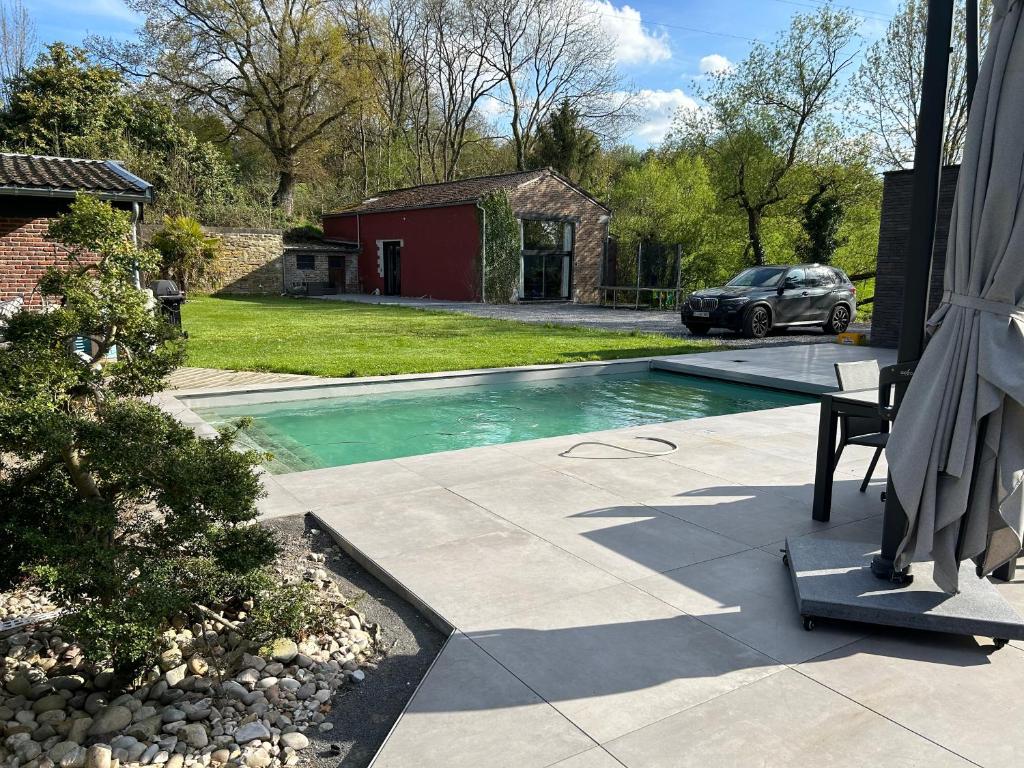 una piscina en un patio con un coche aparcado en Guest House and swimming pool, en Romsée