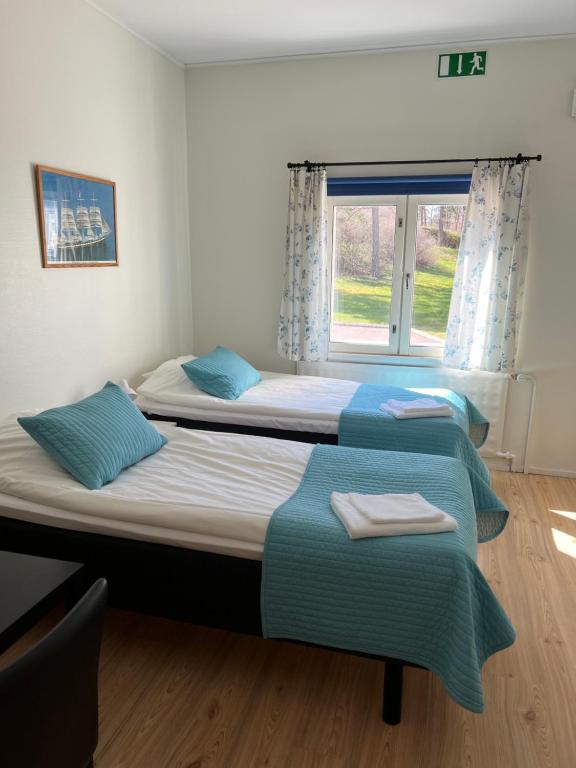 2 camas en una habitación con ventana en Gästhem Neptun en Mariehamn