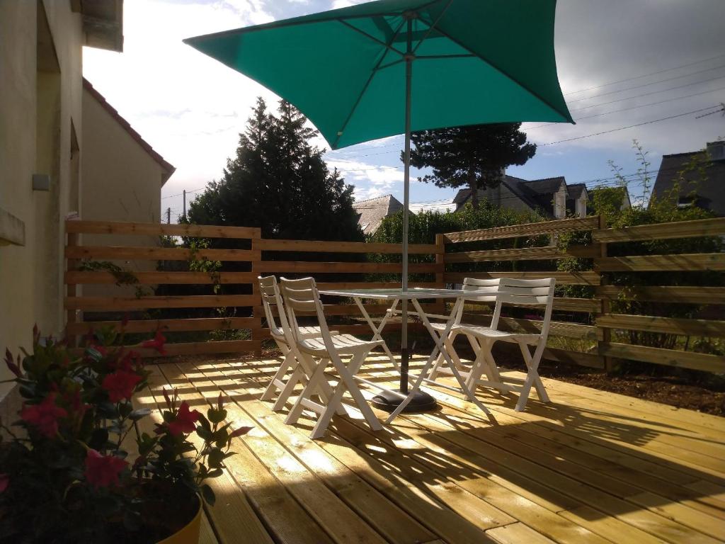 une table et des chaises avec un parasol vert sur une terrasse dans l'établissement T2 charmant avec terrasse 650m de la mer Pornichet, à Pornichet