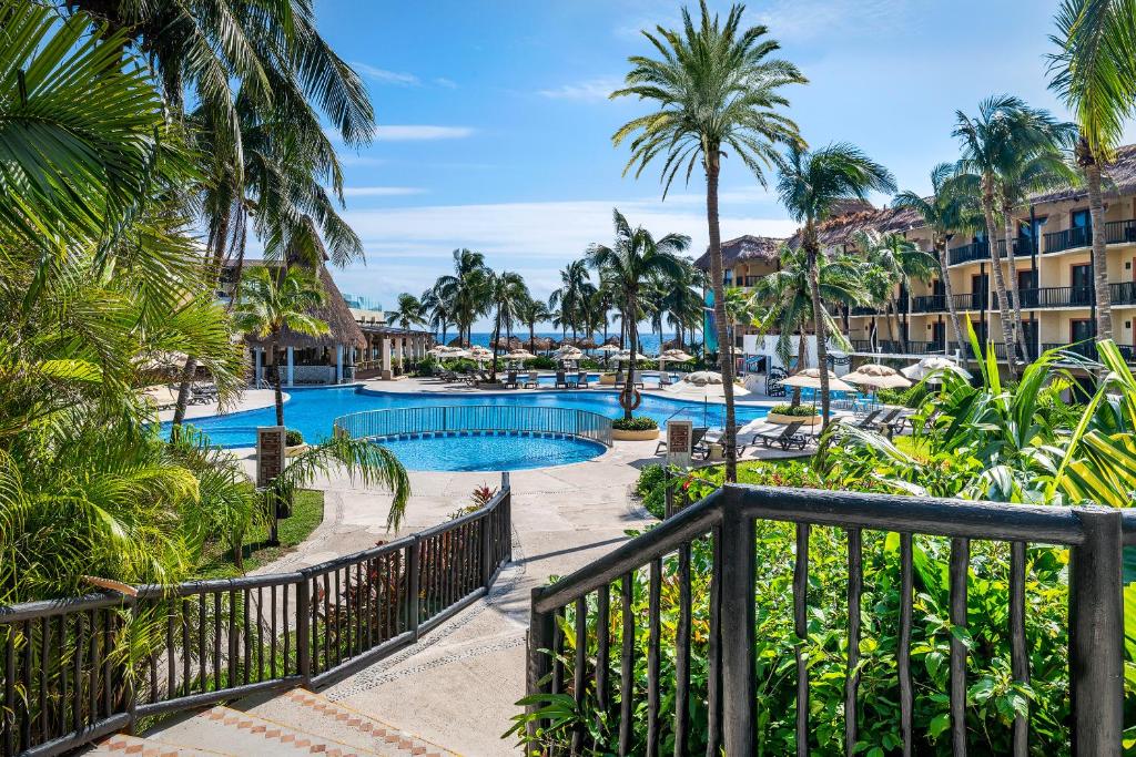uma vista para um resort com uma piscina e palmeiras em Catalonia Yucatan Beach - All Inclusive em Puerto Aventuras