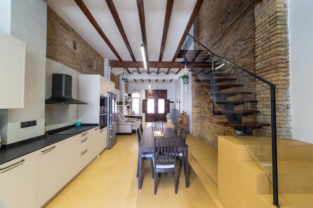 uma cozinha e sala de jantar com uma mesa e uma parede de tijolos em Maritime House Valencia Beach em Valência