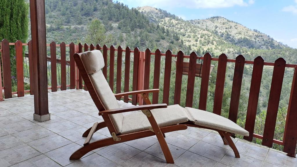 un fauteuil à bascule assis sur une terrasse couverte avec une clôture dans l'établissement Ioannis Ylation, à Nicosie