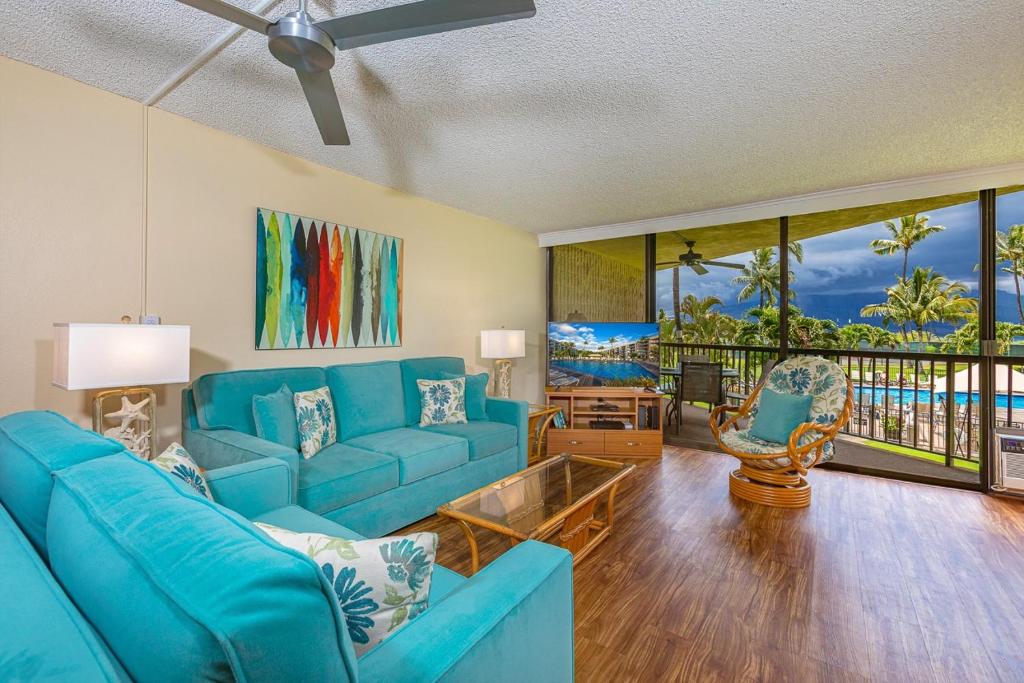 sala de estar con sofá azul y mesa en Maui Sunset B217 condo, en Kihei