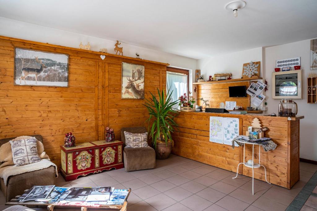 sala de estar con paredes de madera, mesa y sillas en Aparthotel Pedrotti Strembo, en Strembo
