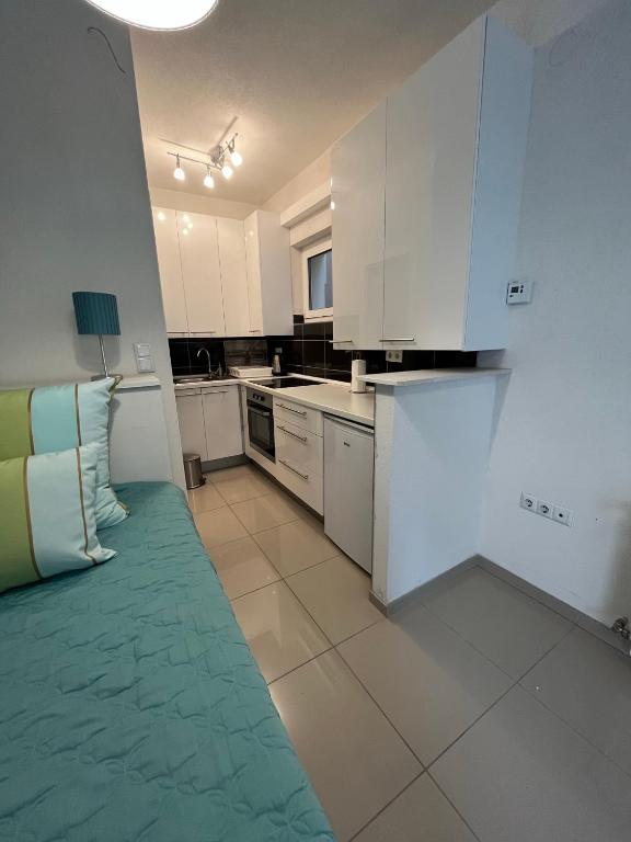 a kitchen with white cabinets and a green rug at APARTMANI VIJEĆNICA in Sarajevo