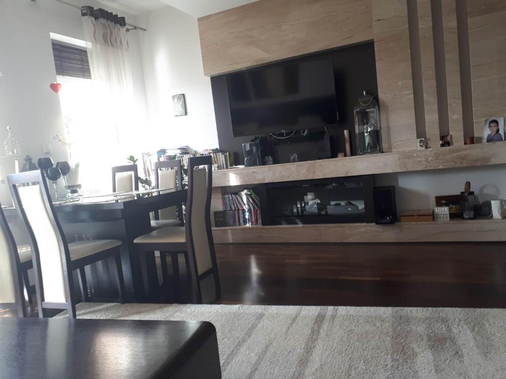 a living room with a counter with a television and a table at Apartament nad jeziorem w Brodnicy in Brodnica