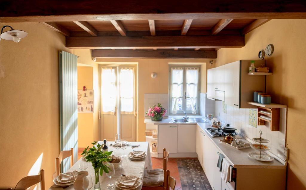 een keuken met een tafel en stoelen in een kamer bij Roero House in Magliano Alfieri