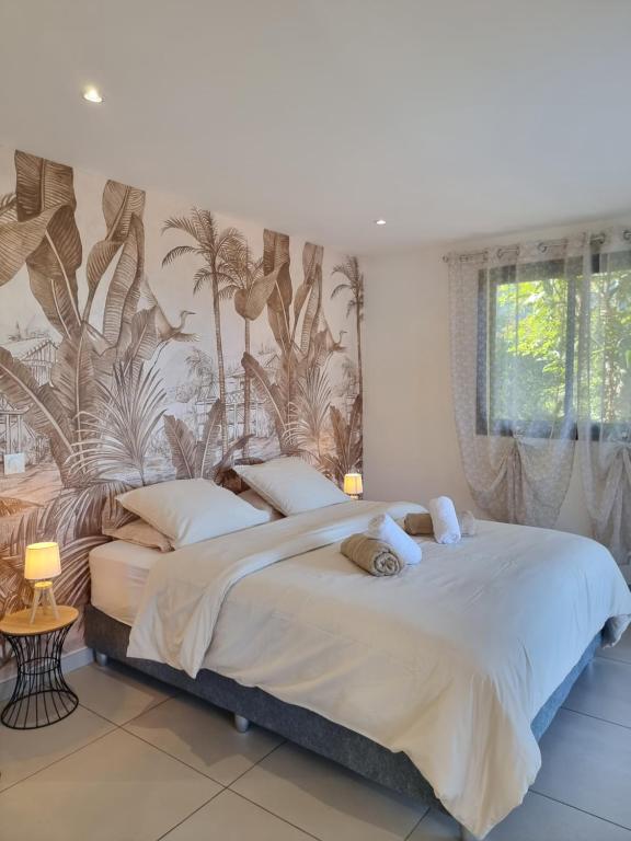 um quarto com uma cama grande e um mural tropical na parede em Le Panorama Intense em Cilaos