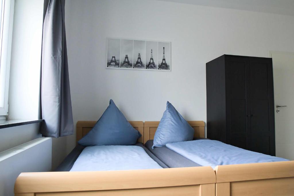 Bett mit blauen Kissen in einem Zimmer in der Unterkunft Heide Ferienwohnung in Schneverdingen