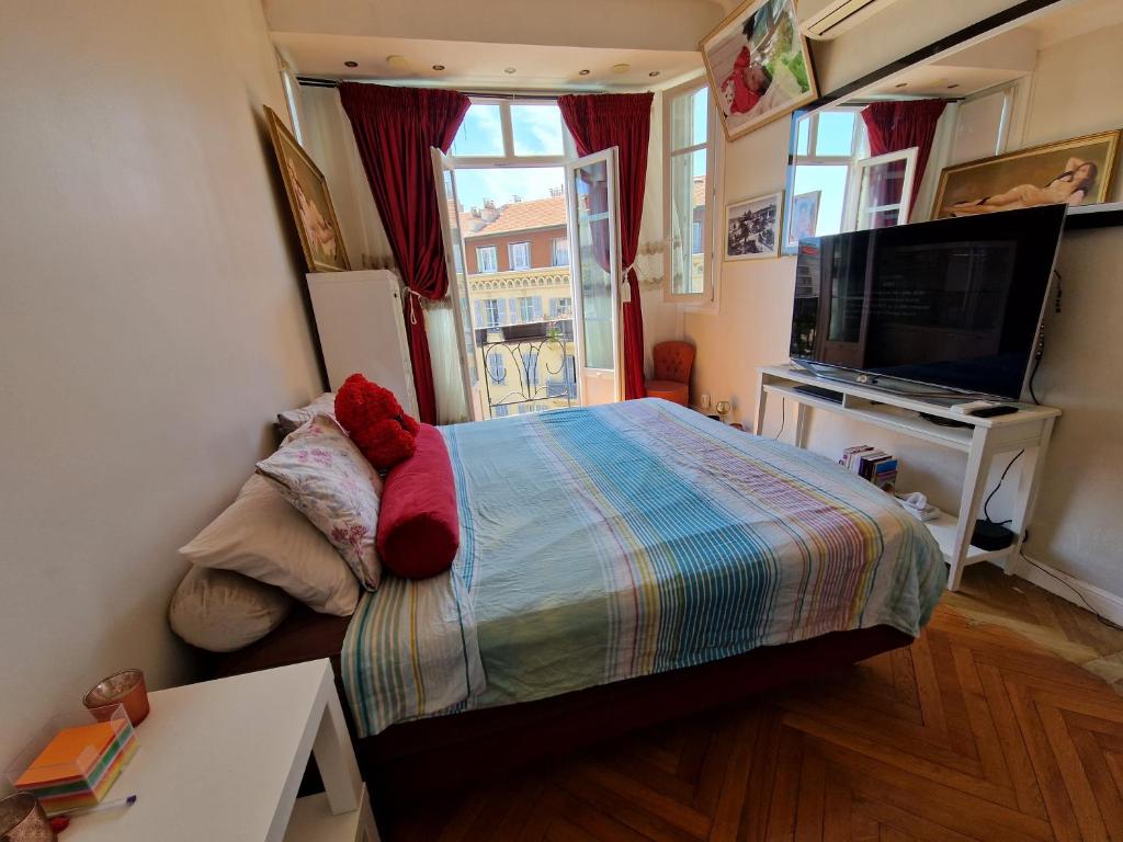 une chambre avec un lit avec un ours en peluche dessus dans l'établissement Nice : Beau trois pièces lumineuse avec vue dégagée., à Nice