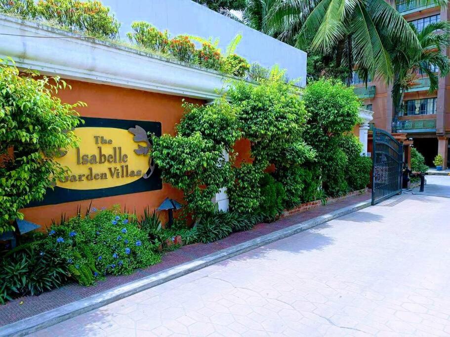 a sign on the side of a building with plants at Isabelle Garden Villas 429 in Manila