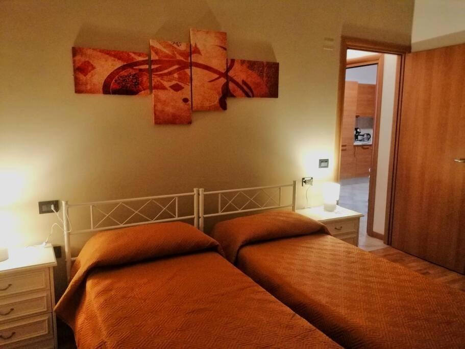 1 cama en un dormitorio con 2 pinturas en la pared en Bilocale NICOL 4 posti Padova ovest, en Padua