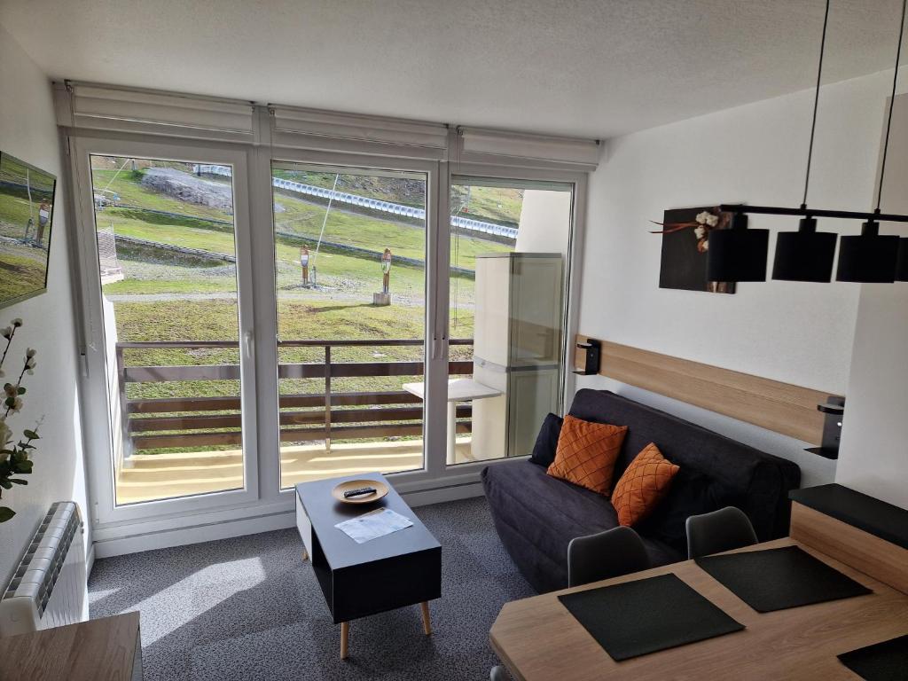 ein Wohnzimmer mit einem Sofa und einem großen Fenster in der Unterkunft Studio Moderne au pied des pistes 4 Pers - La Pierre Saint-Martin GR10 in Arette