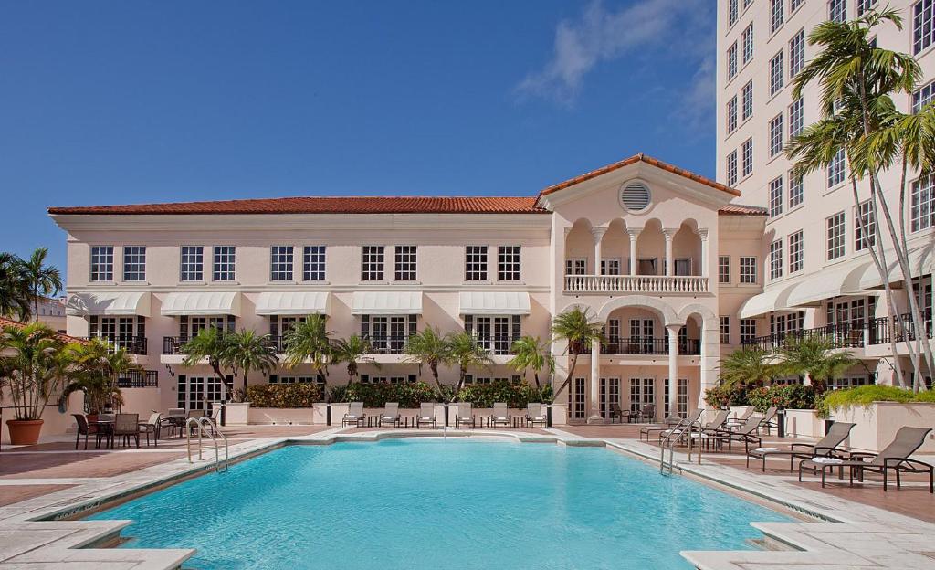 een groot gebouw met een zwembad voor een gebouw bij Hyatt Regency Coral Gables in Miami in Miami