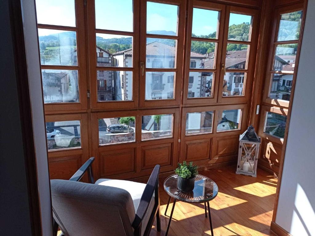 a room with a large window with a table and chairs at Arotzetxea in Elizondo