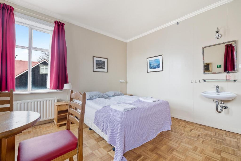una camera con letto, lavandino e tavolo di Baldursbrá Guesthouse Laufásvegur a Reykjavik